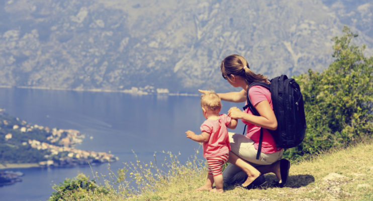 mother with little daughter looking at mountains on vacation